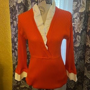 Long-sleeved, business casual or dressy orange sweater with white trimmings.